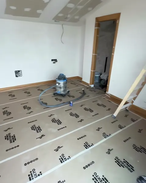 Habitación con todo el suelo cubierto de papel protector y el aspirador listo antes de lijar